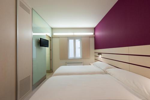 A bed or beds in a room at Hotel Boreal Viento Norte