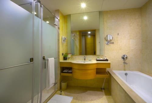 a bathroom with a sink and a tub and a shower at Nice Prince Hotel in Chiayi City