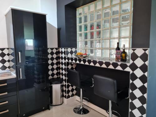 uma cozinha com um bar com azulejos pretos e brancos em Stockton Heights, Warrington, Centrally Located Between Town Centre and Stockton Heath, High Speed Wifi, Cozy Stay em Warrington