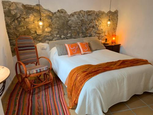 a bedroom with a large bed and a chair at Astarte House 6 pax down in Galera