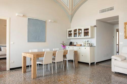 a dining room with a wooden table and white chairs at oltremare soul houses in Chiavari