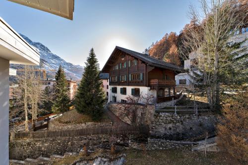 una casa con una montaña en el fondo en Chesa Cuntainta - St. Moritz en St. Moritz