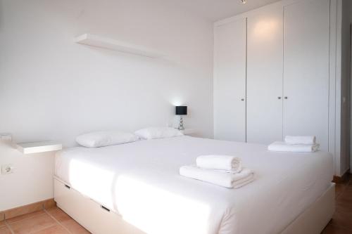 プラヤ・パライソにあるGorgeous Paraiso FREE WIFIの白いベッドルーム(タオル付きの白いベッド付)