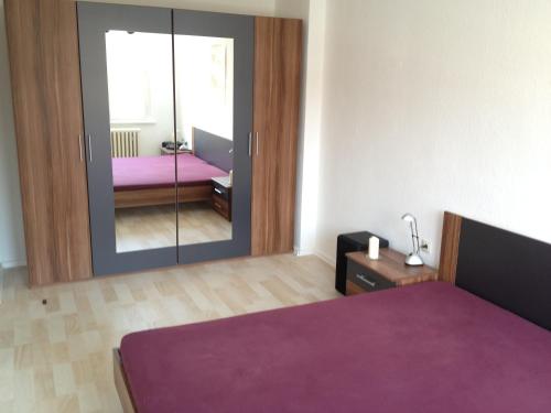 ein Schlafzimmer mit einem lila Bett und einem Spiegel in der Unterkunft "IDEAL" - für Zwei in Berlin