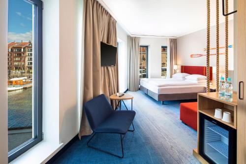 a hotel room with a bed and a chair and a window at Holiday Inn Gdansk - City Centre by IHG in Gdańsk