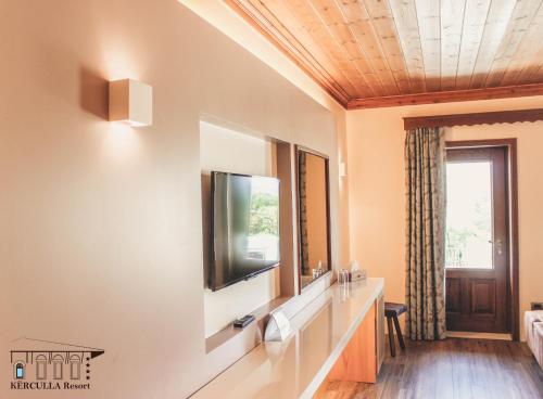 a bathroom with a sink and a television on a wall at KERCULLA Resort in Gjirokastër