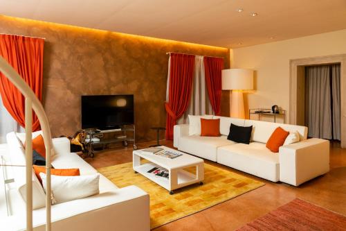 a living room with white furniture and red curtains at La Barchessa di Villa Pisani in Lonigo