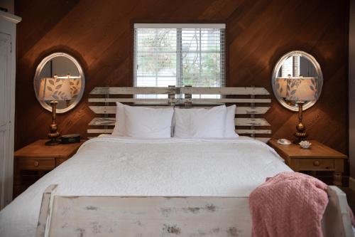 a bedroom with a large bed and two mirrors at J Patrick Inn in Cambria