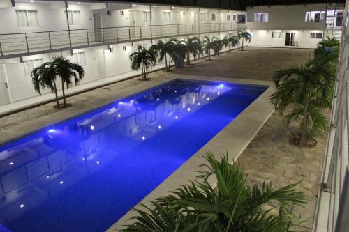 a large swimming pool in a building with palm trees at Hotel Santa Cruz Juchitan in Juchit&aacute;n de Zaragoza