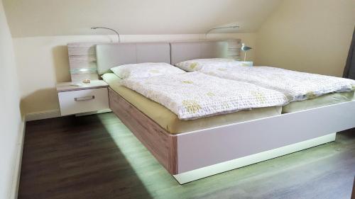 ein Schlafzimmer mit einem weißen Bett und einem Nachttisch in der Unterkunft Ferienwohnung Emmely in Binz