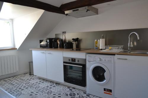 une cuisine avec une machine à laver et un évier dans l'établissement le silencio coeur de ville vu Cathédral, à Chartres