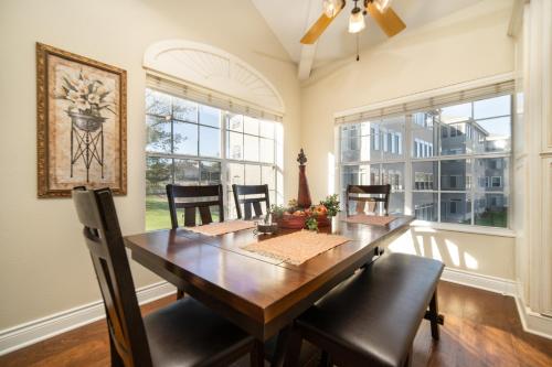 a dining room with a table and chairs and windows at Legacy at Thousand Hills in Branson