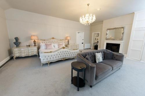 a living room with a bed and a couch at Glewstone Court Country House Hotel in Ross on Wye