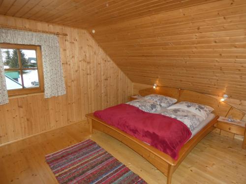 um quarto com uma cama num chalé de madeira em Almhütte Seeberg em Turnau