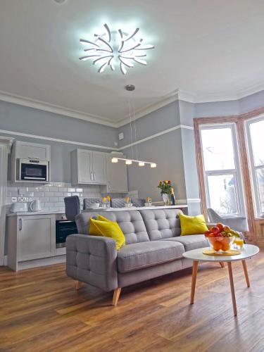 a living room with a couch and a table at Sea Coast Apartment by Seaside Llandudno in Llandudno