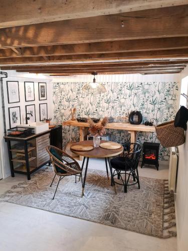 une salle à manger avec une table, des chaises et une cheminée dans l'établissement Studio de charme proche de la gare, et du centre ville, à Rennes