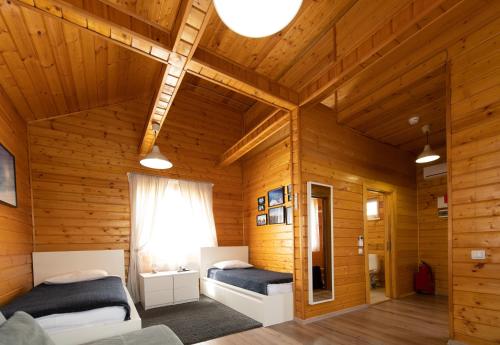 a bedroom with two beds in a wooden room at Hotel Krutitcy in Sasykino