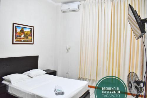 a hotel room with a bed and a fan at Residencial Brest Amazon Tarapoto in Tarapoto