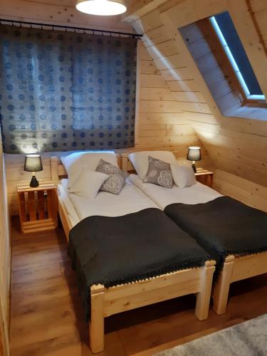 1 dormitorio con 2 camas en una cabaña de madera en Górska Chata Pod wyciągami Remiaszów i Jankulakowski Skibus pod domkami, en Białka Tatrzanska