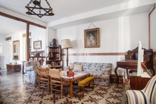 a living room with a couch and a table and a piano at La Casona de Doña Clotilde in Sardón de Duero
