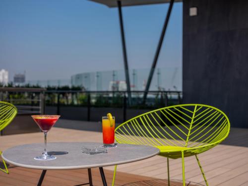 a table and two chairs with drinks on a balcony at Galeria Plaza San Jeronimo in Mexico City