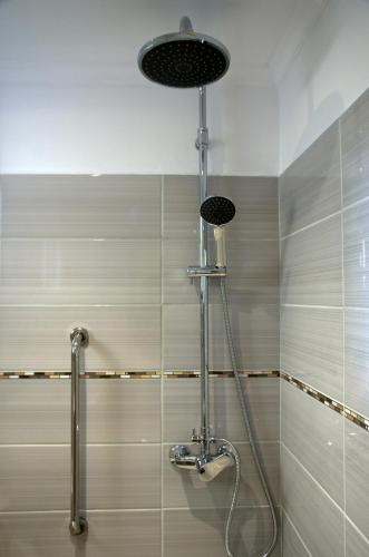 a shower in a bathroom with a shower head at Nicola's Apartments in Kassiopi