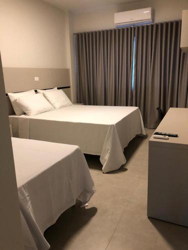 a hotel room with two beds and a window at Raf Hotel in Umuarama