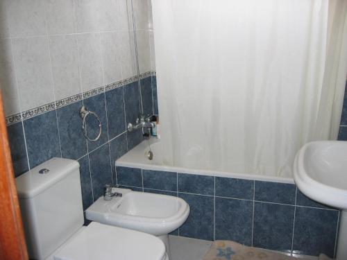 a bathroom with a white toilet and a sink at Pensao Residencial Mirasol in Funchal