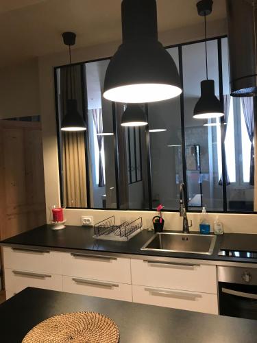 a kitchen with a sink and a large mirror at T2 centre ville avec extérieur in Avignon