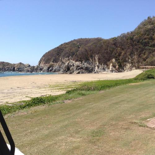 a view of a beach with a hill at Grand Isla Navidad Golf & Spa Resort with Marina in Barra de Navidad