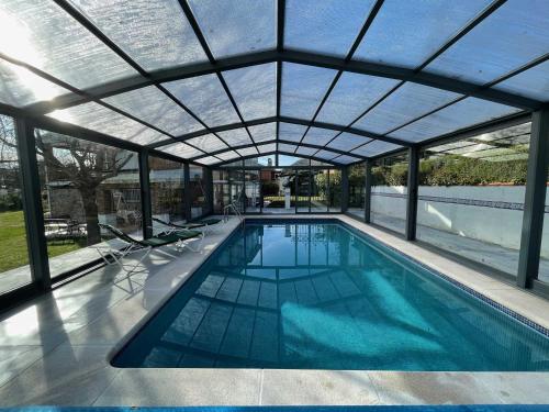 an indoor swimming pool with a glass roof at El Bulín de la Cabrera - Pico de la Miel in La Cabrera