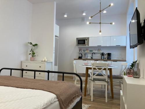 a bedroom with a bed and a table and a kitchen at Duo 1 Debniki Apartment in Krakow