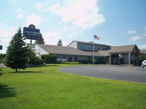 a sign for a hotel in front of a building at AmericInn by Wyndham Rhinelander in Rhinelander