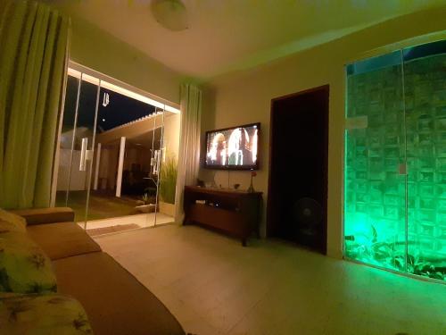 a living room with a flat screen tv and an aquarium at Serra Mar Suítes,Lofts, e casas à 300 metros das praias in Arraial do Cabo