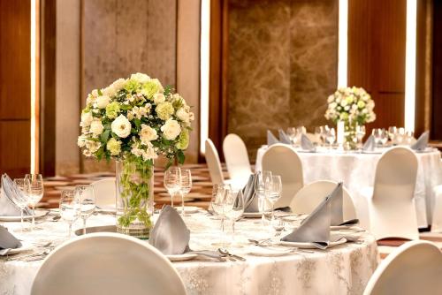 a table set up for a wedding with white flowers at Marco Polo Plaza Cebu in Cebu City