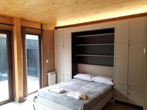 1 dormitorio con 1 cama grande y techo de madera en MONOAMBIENTE en San Martín de los Andes