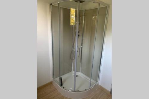 a shower with a glass door in a room at Studio indépendant Lisieux in Lisieux