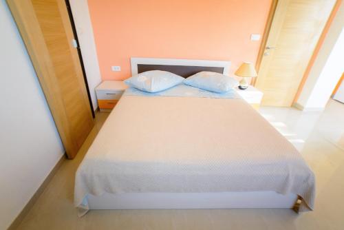 a bedroom with a bed with two pillows on it at Lara Apartments in Makarska