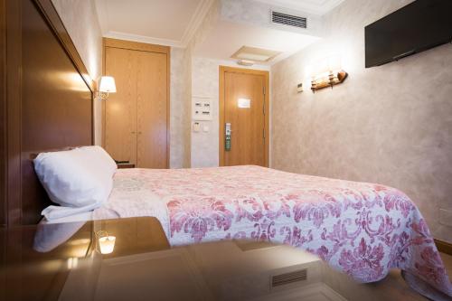 a hotel room with a bed and a table at Abadía Burgos Camino Santiago in Burgos