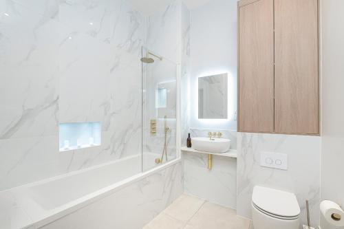 a white bathroom with a shower and a sink at Luxury Romantic Church Getaway in Finchley