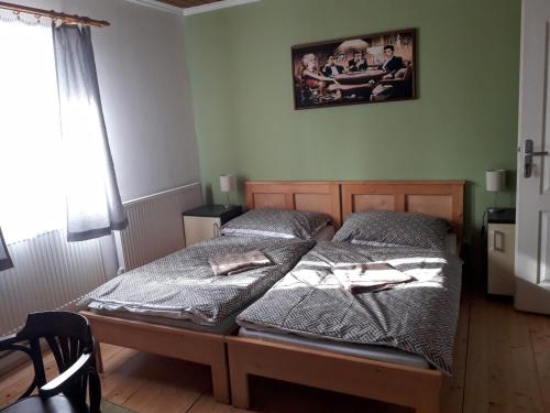 a bedroom with two twin beds and a picture on the wall at Penzion Na Střelnici in Poděbrady