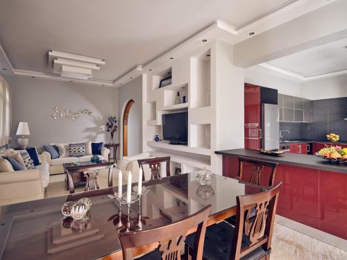 a kitchen and living room with a table and chairs at Villa Castelletto heated pool jacuzzi in Kipseli