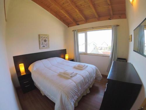 Un dormitorio con una cama grande y una ventana en Laderas Blancas en Caviahue