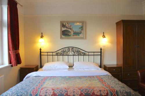 a bedroom with a large bed with two pillows at The Dial House Guest House in Oxford