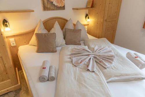a bed with white sheets and a bow on it at Appartements Umfahrer in Tröpolach