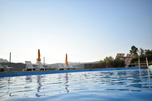 a swimming pool at a resort with chairs at Casa da Eira in Janeiro de Cima