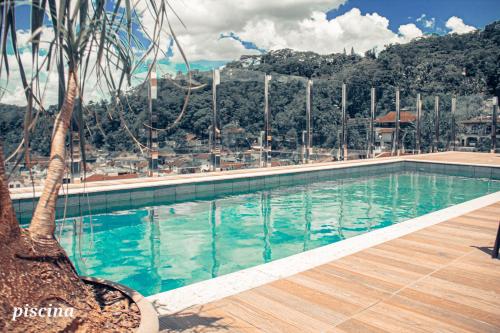 uma grande piscina com uma palmeira ao lado em Loft com vista para Vila Germânica 309 em Blumenau