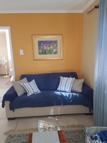 a blue couch in a living room with a painting at Bibi's Place in Swakopmund