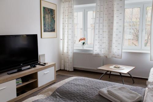 d'un salon avec une télévision à écran plat et des fenêtres. dans l'établissement Apartament urokliwa Długa, à Gdańsk