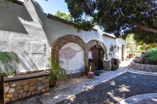 a house with a stone wall and a gate at Quinta Monasterio in Valle de Guadalupe